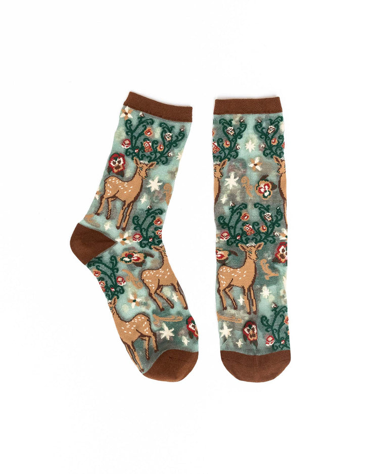 A pair of sheer Sock Candy socks with a deer and floral design against a white background.