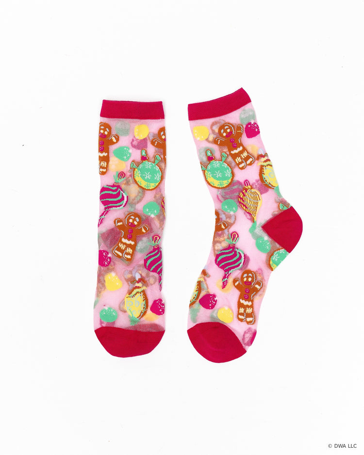 A pair of sheer pink Shrek Gingy socks designed by Sock Candy with a colorful Christmas-themed print featuring gingerbread men, lollipops, ornaments, and strawberries on a white background.