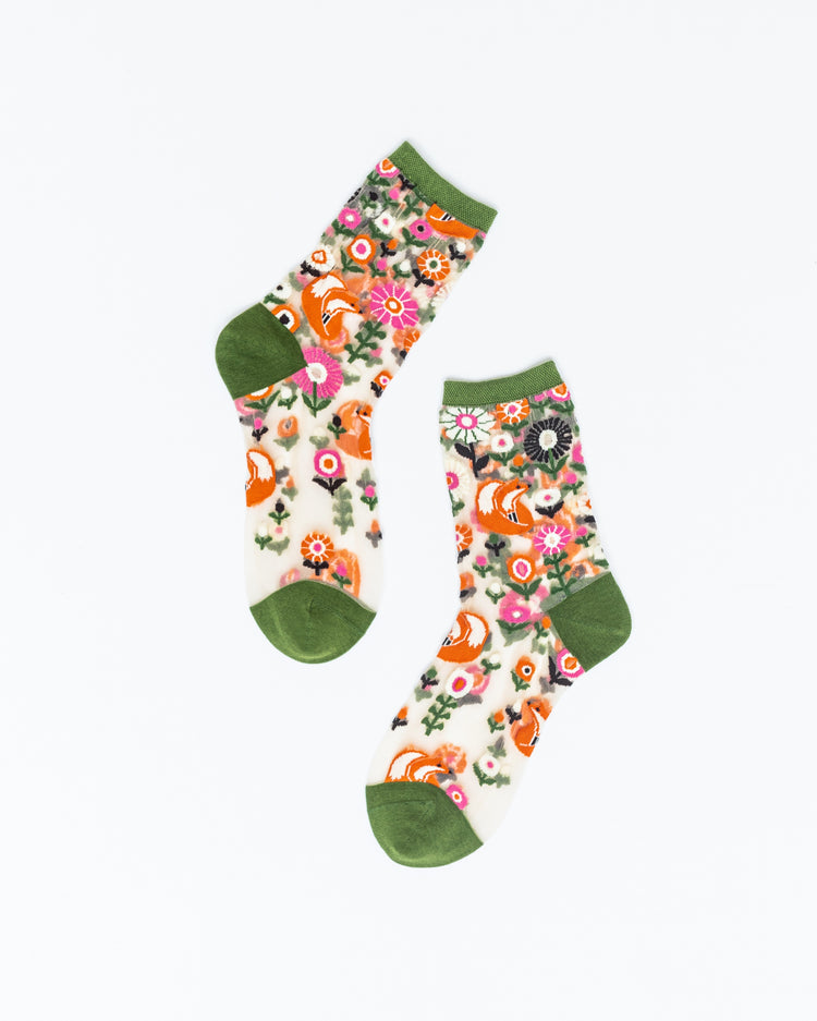 A pair of sheer Sock Candy socks featuring a cute fox and floral motif against a white background.